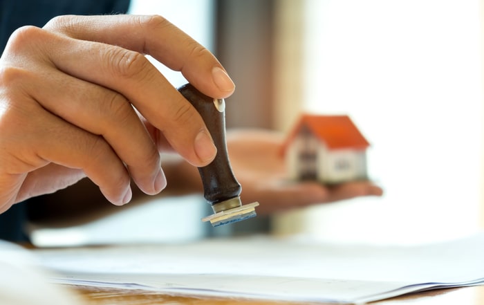 close-up-rubber-stamp-and-model-house-in-hand
