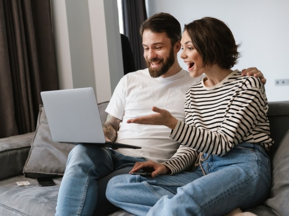 happy-young-white-couple-looking-at-laptop